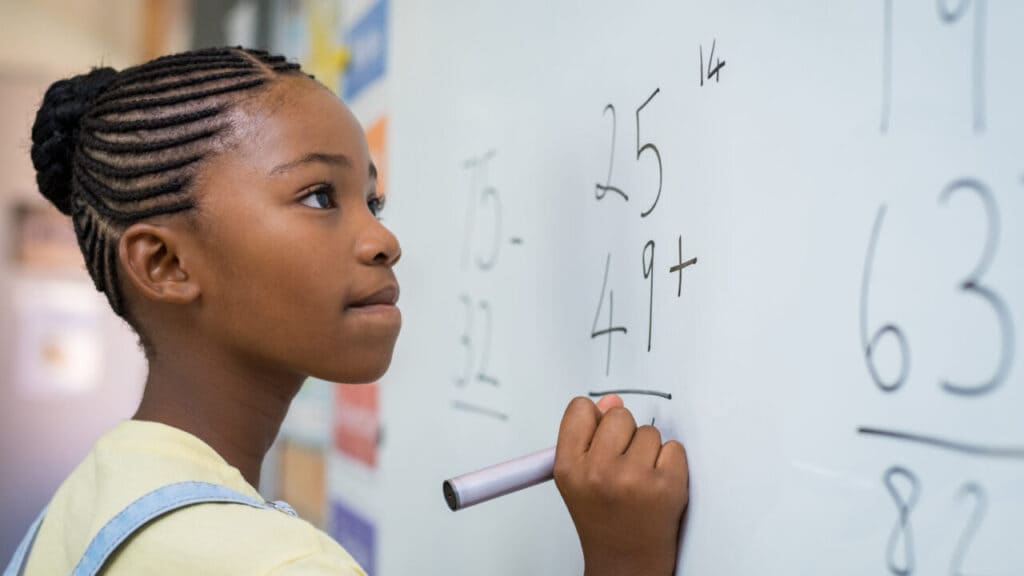 Black student solving math problem, theGrio.com