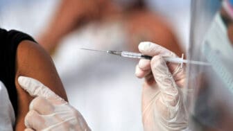 A health worker gives a man a shot of the Jenssen COVID-19 vaccine from the Johnson & Johnson - theGrio.com